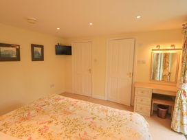 A bedroom with a bed and television at Pheasant Cottage Beckside near Cartmel