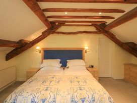 A bedroom with a bed and bedside table at Pheasant Cottage Beckside near Cartmel