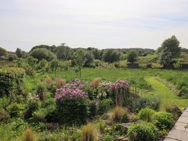 A garden with flowers and greenery at Pheasant Cottage Beckside near Cartmel