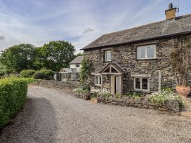 A house with a garden and driveway at Kestrel Cottage in Beckside near Cartmel