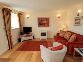 A living room with a sofa and television at Kestrel Cottage near Cartmel