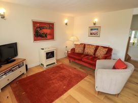 A living room with a sofa and television at Kestrel Cottage Beckside near Cartmel