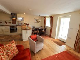 A dining area with kitchen and seating at Kestrel Cottage Beckside near Cartmel