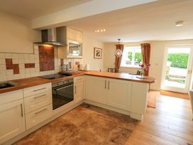 A kitchen with countertop and appliances at Kestrel Cottage Beckside near Cartmel