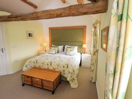 A bedroom with a bed and nightstands at Kestrel Cottage Beckside near Cartmel