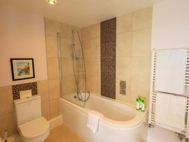 A bathroom featuring a bathtub and shower at Kestrel Cottage Beckside near Cartmel