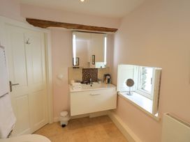 A bathroom with sink and mirror at Kestrel Cottage Beckside near Cartmel