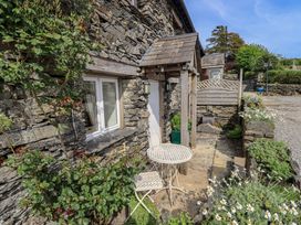 An outdoor area with a table and chair at Kestrel Cottage Beckside near Cartmel