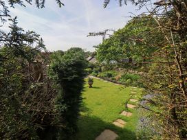 A garden with a pathway and greenery at Kestrel Cottage in Beckside near Cartmel