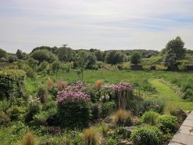 A garden view with flowers and a pathway at Kestrel Cottage near Cartmel