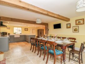 A kitchen and dining area with wooden beams and a dining table with chairs at Copmanthorpe Hall in Copmanthorpe
