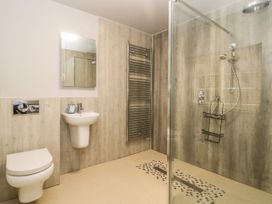 A bathroom with a wall-mounted toilet sink mirror shower and towel radiator at Copmanthorpe Hall in Copmanthorpe
