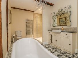 A bathroom with a freestanding bathtub a toilet a wall-mounted towel heater a shower and a vanity unit with a decorative mirror at Copmanthorpe Hall in Copmanthorpe