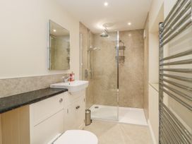 A bathroom with shower area a sink a mirror and a heated towel rail at Copmanthorpe Hall in Copmanthorpe