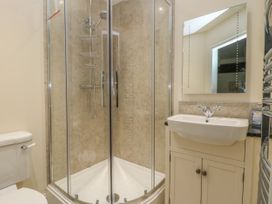 A bathroom with a shower enclosure a sink with cabinet a mirror a toilet and a heated towel rail at Copmanthorpe Hall in Copmanthorpe