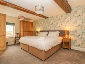 A bedroom with a double bed bedside tables lamps a wooden wardrobe and floral wallpaper at Copmanthorpe Hall in Copmanthorpe