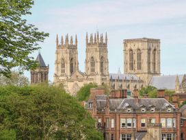 A cityscape with a cathedral and brick buildings surrounded by trees at Copmanthorpe Hall in Copmanthorpe