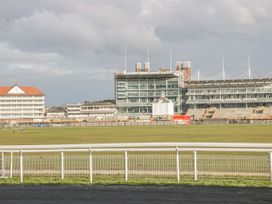 A racecourse with grandstands and a large grass field at Copmanthorpe Hall in Copmanthorpe