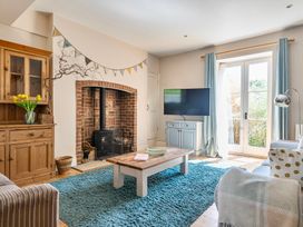 A living room with a wood stove and a television at East Wing in Crewkerne