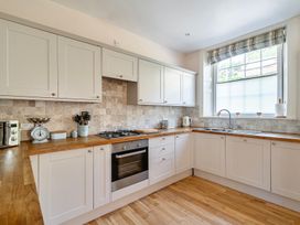 A kitchen with cabinets and stove at East Wing in Crewkerne