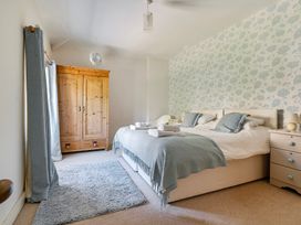 A bedroom with a bed, wardrobe, and nightstand at East Wing in Crewkerne