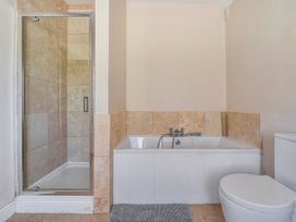A bathroom with a shower, bathtub, and toilet at East Wing in Crewkerne