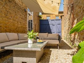 An outdoor patio with a couch and table at East Wing in Crewkerne