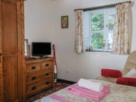 A bedroom with a television and wardrobe at The Old Workshop in Knowstone