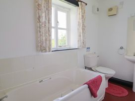 A bathroom with a bathtub and toilet at The Old Workshop in Knowstone