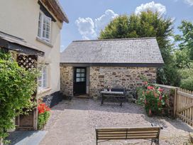 An outdoor area with a bench and table at The Old Workshop in Knowstone