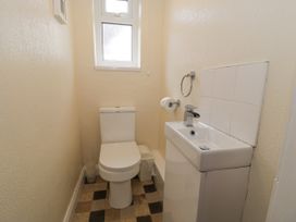 A small bathroom with a toilet and a sink under a frosted window at Maesdu Cottage in Llandudno