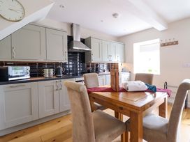 A kitchen with dining table and chairs at Moelfre Cottage Llanbedr