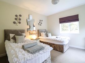A bedroom with two beds and a lamp at Moelfre Cottage in Llanbedr