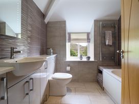 A bathroom with a sink, toilet, and bathtub at Moelfre Cottage in Llanbedr