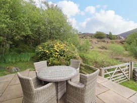 A garden with a table and chairs at Moelfre Cottage Llanbedr