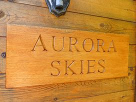 A wooden sign with the text Aurora Skies mounted on a wooden wall at Aurora Skies in Cresswell near Morpeth