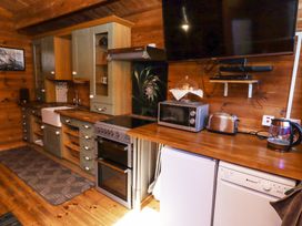 A kitchen with wooden countertops cabinets appliances and a wall mounted television at Aurora Skies in Cresswell near Morpeth