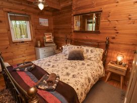 A bedroom with a bed floral bedding bedside tables and a window at Aurora Skies in Cresswell near Morpeth