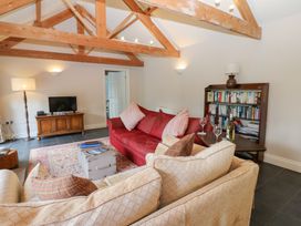 A living room with a sofa, TV, and bookshelf at Gallow Law Cottage in Bellingham