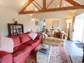 A living room with a red sofa and bookshelves at Gallow Law Cottage Bellingham