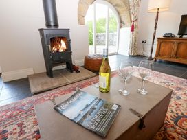 A living room with a fireplace and wine glasses at Gallow Law Cottage Bellingham