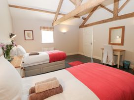 A bedroom with two beds and a mirror at Gallow Law Cottage in Bellingham