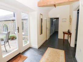 A hallway with a door, mirrors, table, and chair at Gallow Law Cottage in Bellingham