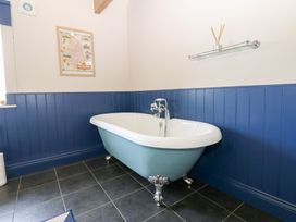 A bathroom with a bathtub and a wall map at Gallow Law Cottage Bellingham