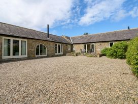 An outdoor area with a gravel surface and seating at Gallow Law Cottage Bellingham
