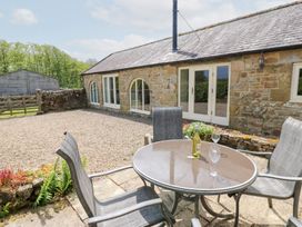 An outdoor seating area with a table and chairs at Gallow Law Cottage Bellingham