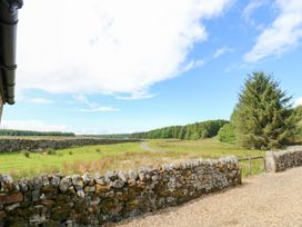 A view of a stone wall and trees at Gallow Law Cottage, Bellingham
