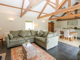 A living room with a sofa, table, and chairs at Shepherds Burn Cottage in Bellingham