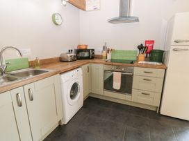 A kitchen with appliances and cabinets at Shepherds Burn Cottage in Bellingham