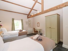 A bedroom with two beds and a desk at Shepherds Burn Cottage Bellingham